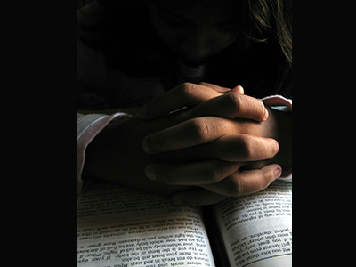 Praying-hands-on-Bible-bing-400-300-trans-border